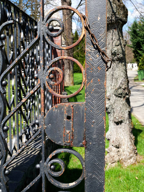 Old rusty ornate metal door of the cemetery Old rusty ornate metal door of the cemetery rusty fence stock pictures, royalty-free photos & images