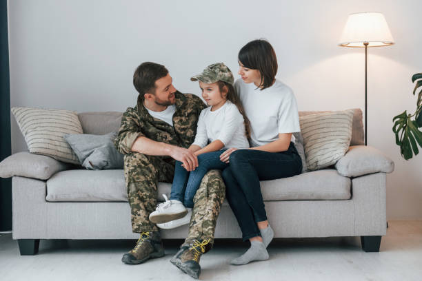 embracing each other. soldier in uniform is at home with his wife and daughter - domestic life young family family child imagens e fotografias de stock