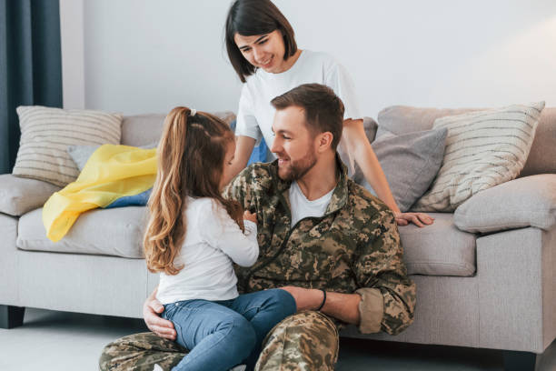 soldier in uniform is at home with his wife and daughter - domestic life young family family child imagens e fotografias de stock