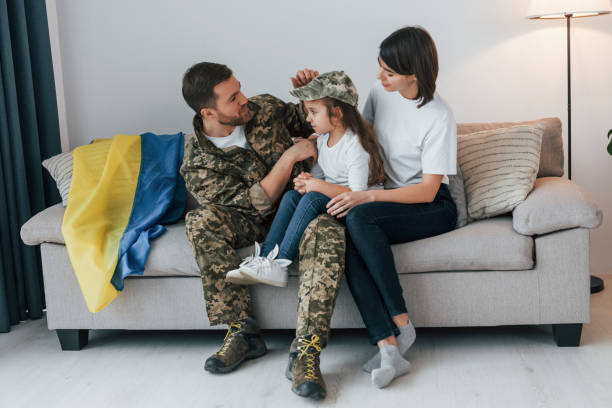 supoort ukraine conception. soldier in uniform is at home with his wife and daughter - domestic life young family family child imagens e fotografias de stock