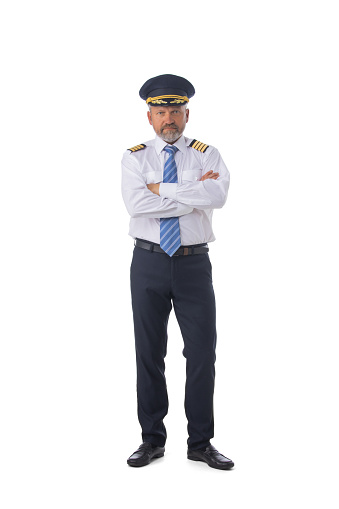 Senior adult airline first pilot aircraft commander standing with arms folded isolated on white background, full length portrait