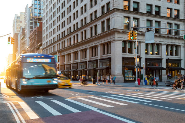 scena di strada trafficata con persone, autobus e taxi all'incrocio tra la 23rd e la 5th avenue a new york city con sfondo di luce solare - motor vehicle outdoors crowd landscape foto e immagini stock