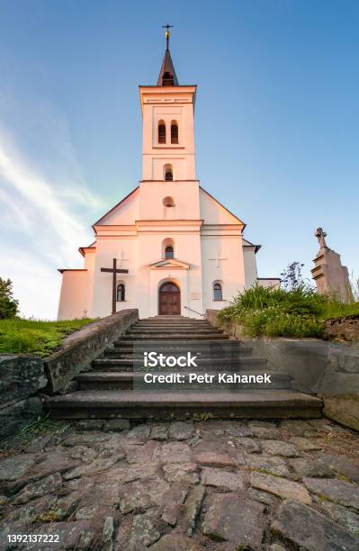 Small Old Christian Church With A Graveyard In Front In The Golden Hour Saint Ignatius Church In Malenovice Czech Republic Stock Photo - Download Image Now