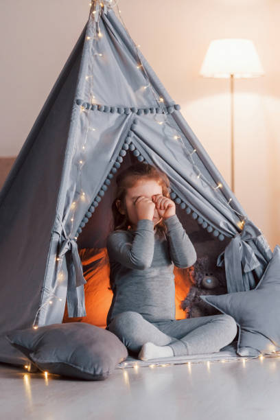 poranek. urocza dziewczynka bawiąca się w namiocie, który znajduje się w pokoju domowym - domestic tent zdjęcia i obrazy z banku zdjęć
