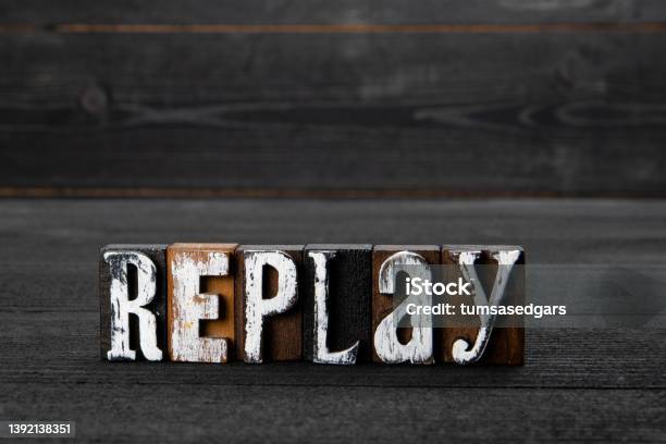 Replay Text On A Dark Textured Wooden Background Stock Photo - Download Image Now - Replay, Time, Abstract
