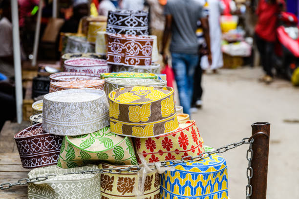 африканские традиционные шляпы кофии продаются на базарном рынке в каменном городе. занзибар, танзания - kufi стоковые фото и изображения