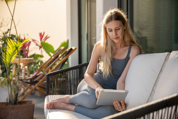 istock Young woman working online from abroad, she uses a digital tablet 1392141003