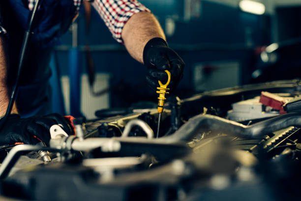 istock Car mechanic checking oil level in a mechanical workshop 1392141297