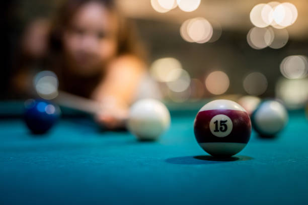 istock young pretty woman playing alone snooker holding cue at pool table 1392149370