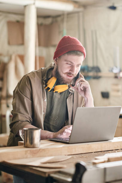 istock Young Woodworker Talking On Phone 1392149865