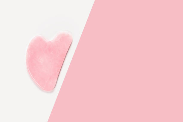 istock Jade facial massage roller on white pink background. 1392151693