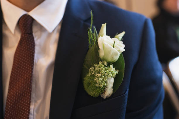 istock Groom at a wedding with a boutonniere of white eustoma 1392152374