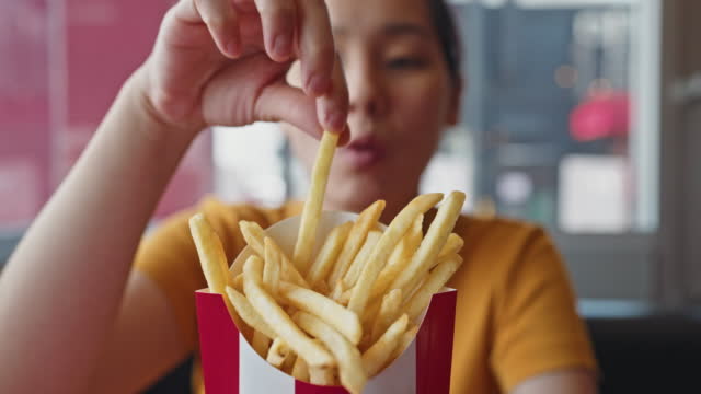 Woman eating French fries