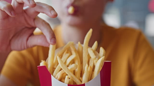 Close-up Woman eating french fries