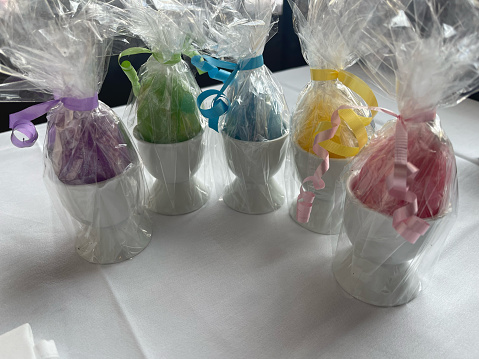 Decorative Easter Eggs in cups wrapped in cellophane background with copy space