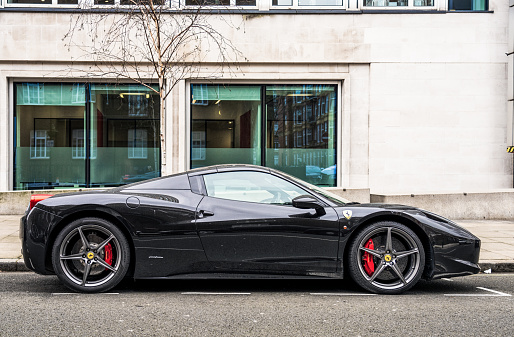 London, UK - Side view of a black Ferrari 458, parked on a residential street in Marylebone, London.