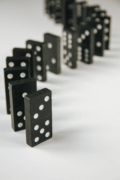 istock Black dominoes chain on white table background 1392164799