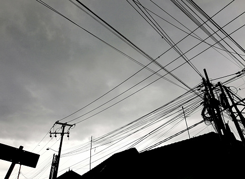 Electric cables on the street against sky