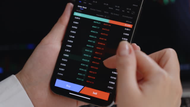Investor checking Bitcoin, Ethereum and other altcoin cryptocurrency price index on mobile phone smartphone screen. Financial analyst working. Cryptocurrency future price action prediction concept