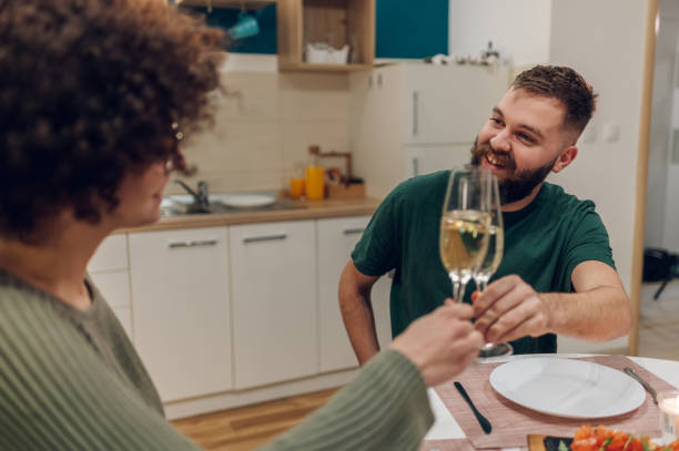istock Friends sitting at a kitchen table and toasting during a dinner part 1392166194