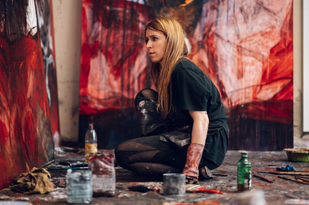 istock Female painter artist painting and creating her art in a creative studio 1392166212