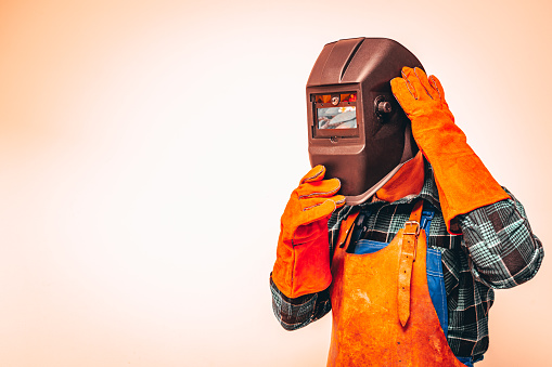 Heavy industry worker in a protective suit with a mask to protect the eyes and face, fiery colors, Space for text