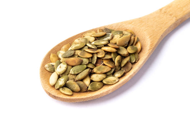 istock Pumpkin seeds in a spoon isolated over white background 1392167706