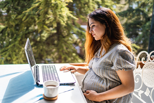 Pregnant woman on vacation checking emails