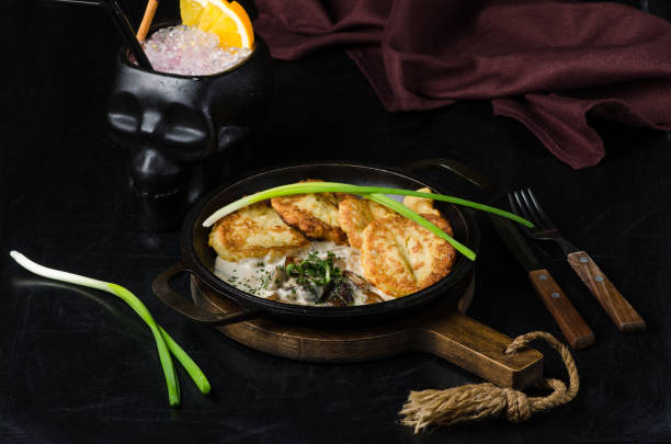 panqueques de patata con stroganoff de ternera en un plato gris sobre la mesa de madera - hash brown gold food vegetable fotografías e imágenes de stock