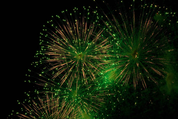 istock Green and golden sparks of fireworks exploding in the sky and smoke from the charges 1392170439