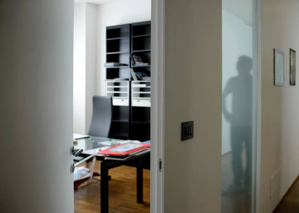 istock Business office with a man reflex in glass door 1392170627