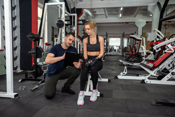 istock happy healthy friendly male trainer conducts personal training with beautiful client. 1392171922