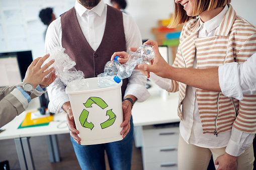 Environmentally focused employees recycling together in the office