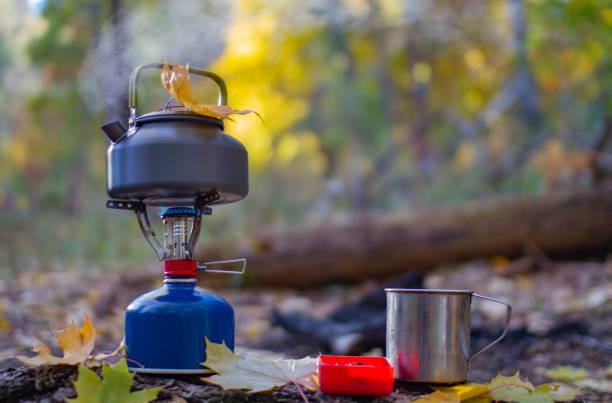 自然の中でピクニック。ガスバーナーとホットティーのマグカップ。 - burner ストックフォトと画像
