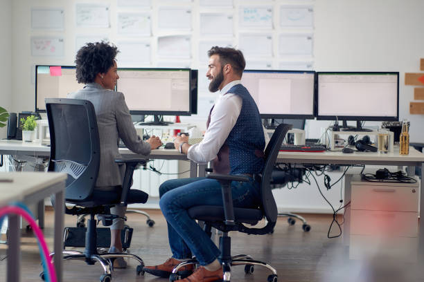 istock Two young attractive coworkers discussing together 1392173187