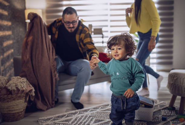 istock Baby boy playing at home while his father is sleeping 1392173304