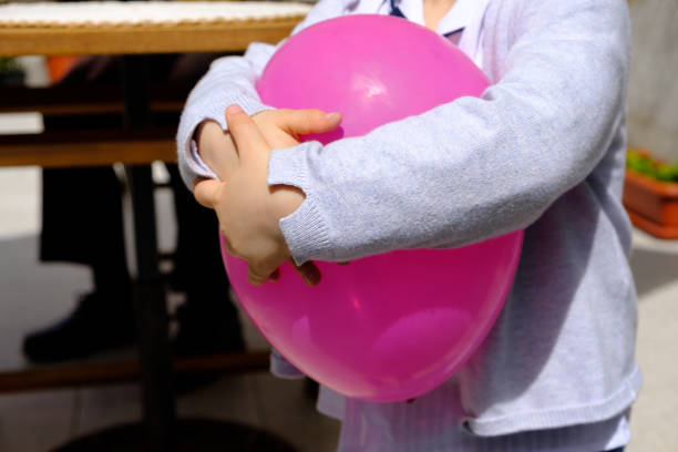 Baby holding a pink balloon