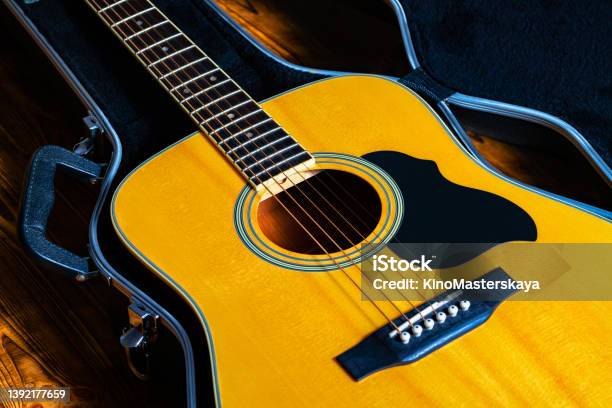 Wooden Yellow Acoustic Guitar Lying In A Hard Case Stringed Musical Instrument In A Black Open Wardrobe Trunk Part Of The Body Of A Acoustic Guitar With Fretboard Sound Hole And Strings Close Up Stock Photo - Download Image Now