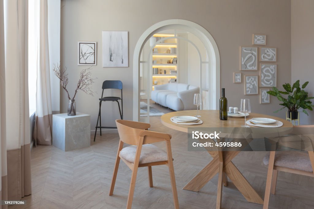 fashionable modern design luxury apartment in light colors. fashionable modern design luxury apartment in light colors. bright day behind huge windows. stylish decoration and no one inside. Living Room Stock Photo