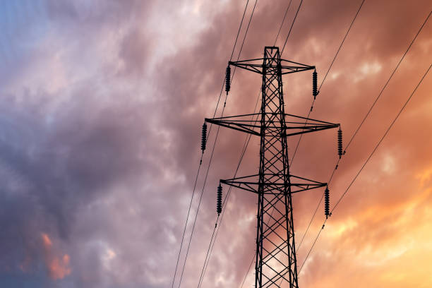 Detail of a British Style Electricity Pylon and suspended electic cables against a Blue Cloudy Sky Detail of a British Style Electricity Pylon and suspended electic cables against a Blue Cloudy Sky blackout stock pictures, royalty-free photos & images
