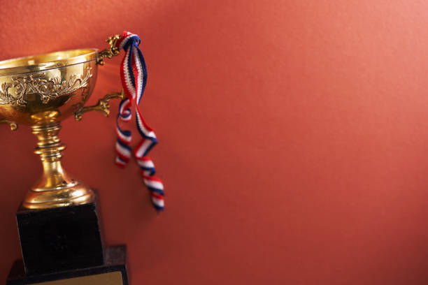 gold trophy against red background - effort gold indoors studio shot imagens e fotografias de stock