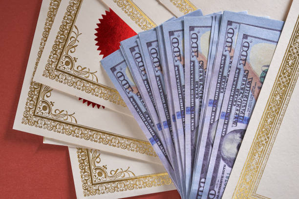 istock certificate or bond and USA currency against red background 1392179988