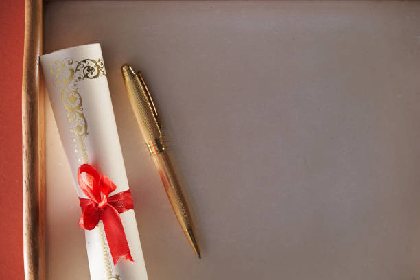 istock gold colored pen and scroll of certificate with ribbon 1392180008