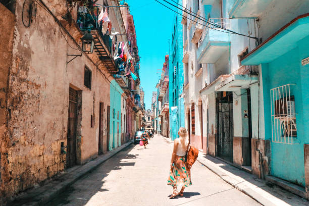 Tourist woman walking on a street of Old Havana Tourist woman walking on a street of Old Havana downtown in a hot sunny day, Cuba cuba stock pictures, royalty-free photos & images