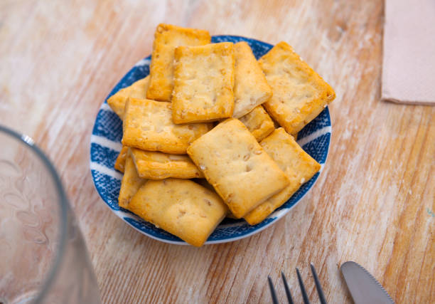 Delicious crackers in a plate on a wooden table. Close-up image