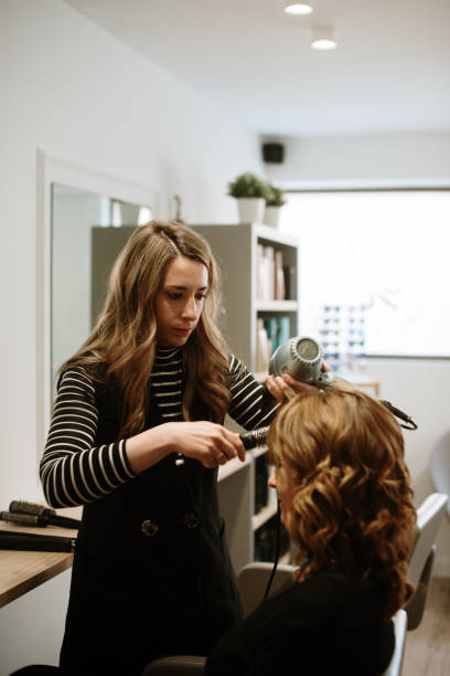 Hairdresser working in a hair salon stock photo