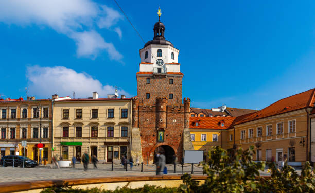 Picturesque Lublin cityscape with historic symbol of city - medieval brick gate Brama Krakowska in sunny spring day, Poland