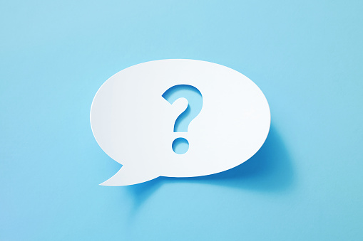 Circular white chat bubble with cut out question mark sitting on blue background. Horizontal composition with copy space. Social media concept.