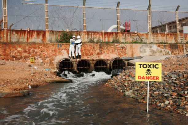 wissenschaftler oder biologen in schutzuniformen analysieren den abwasserfluss ins meer - medical waste stock-fotos und bilder