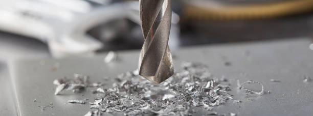 istock metal drill bit make holes in aluminium plate on industrial drilling machine. Metal work industry. 1392193033